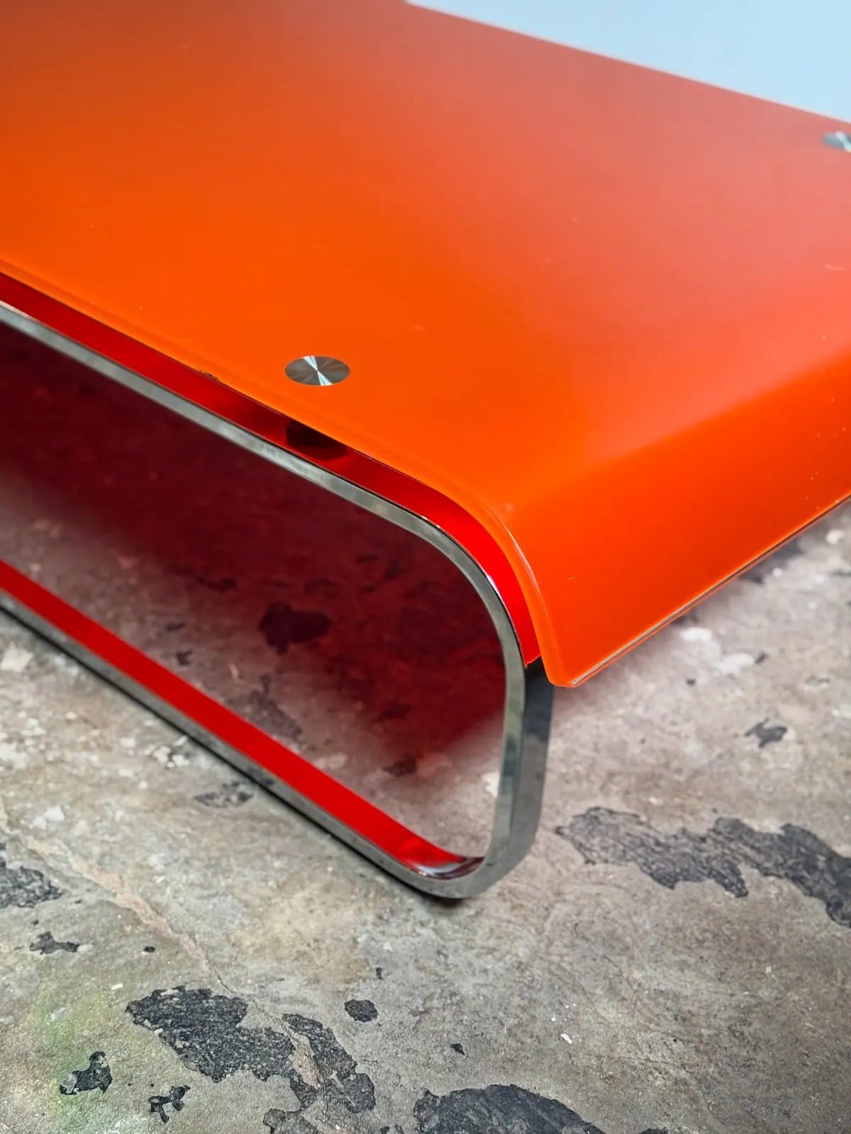 Coffee table with orange glass top, chrome